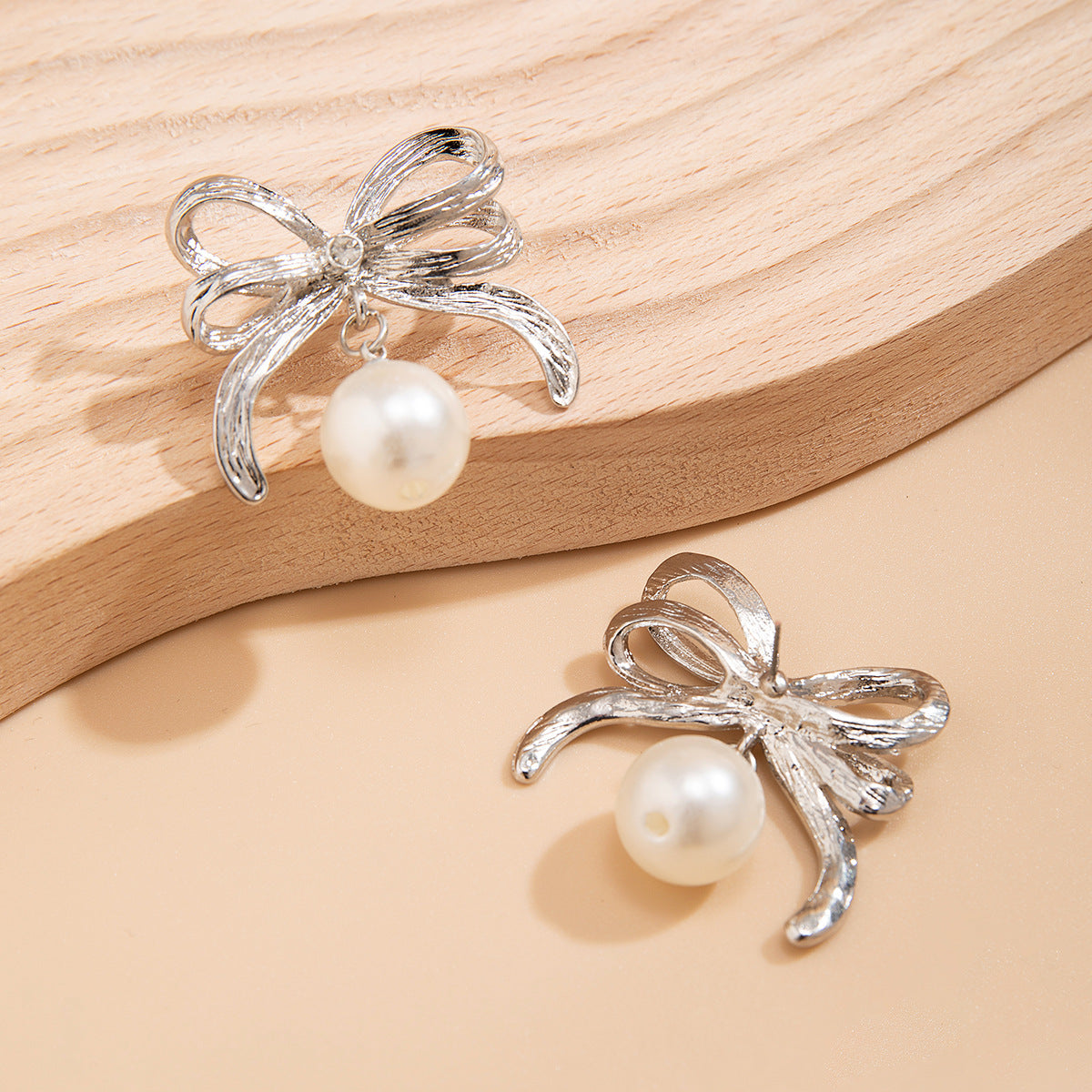 Bow-shaped earrings and rings with pearls