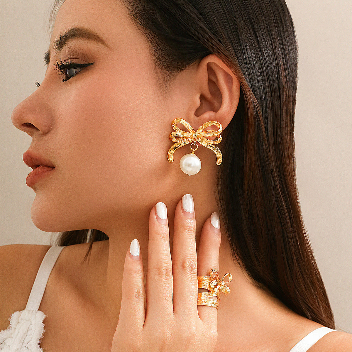 Bow-shaped earrings and rings with pearls