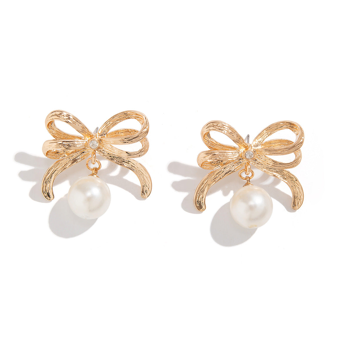 Bow-shaped earrings and rings with pearls